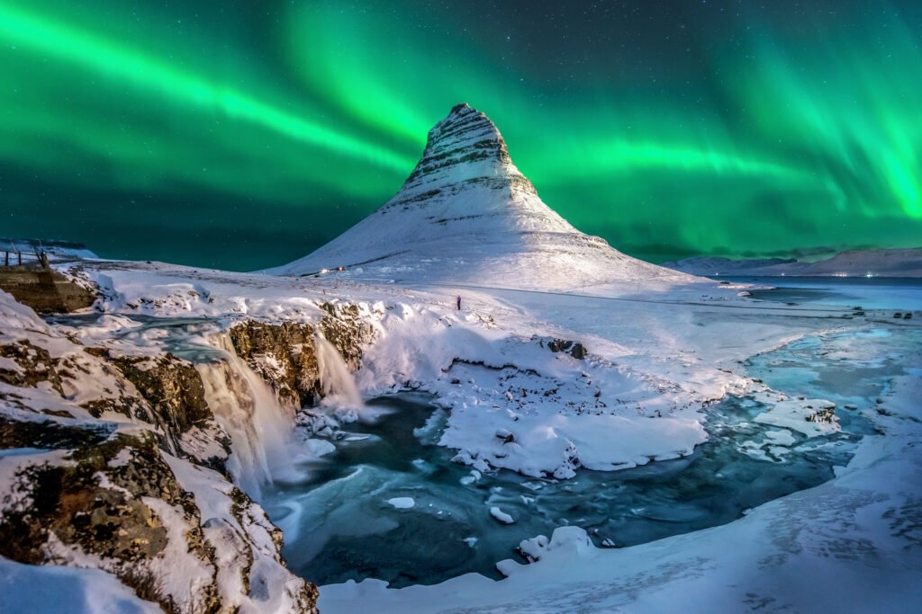 The Aurora Borealis illuminating the night sky above a snowy Icelandic landscape